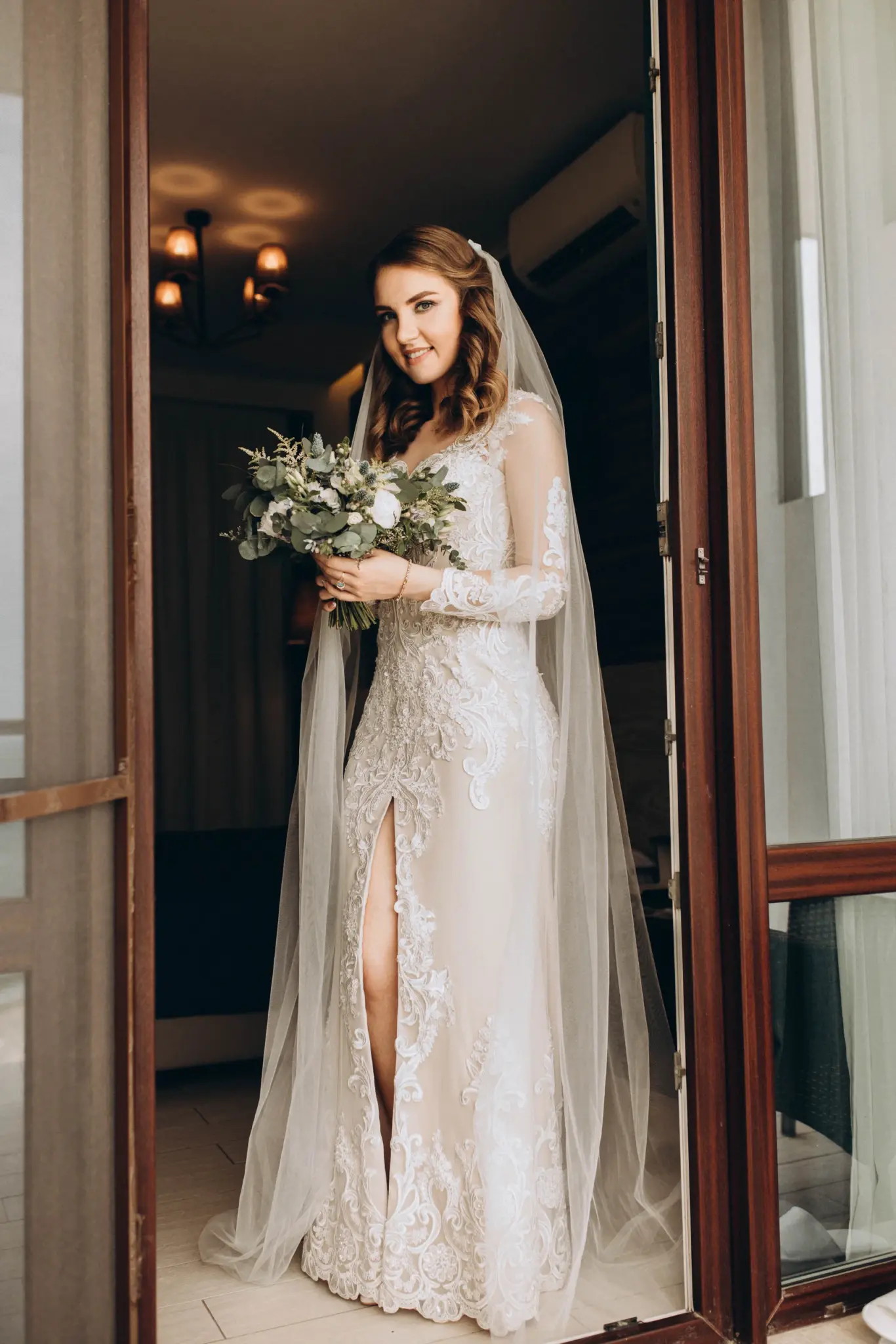 The bride in her dress and veil with a bouquet