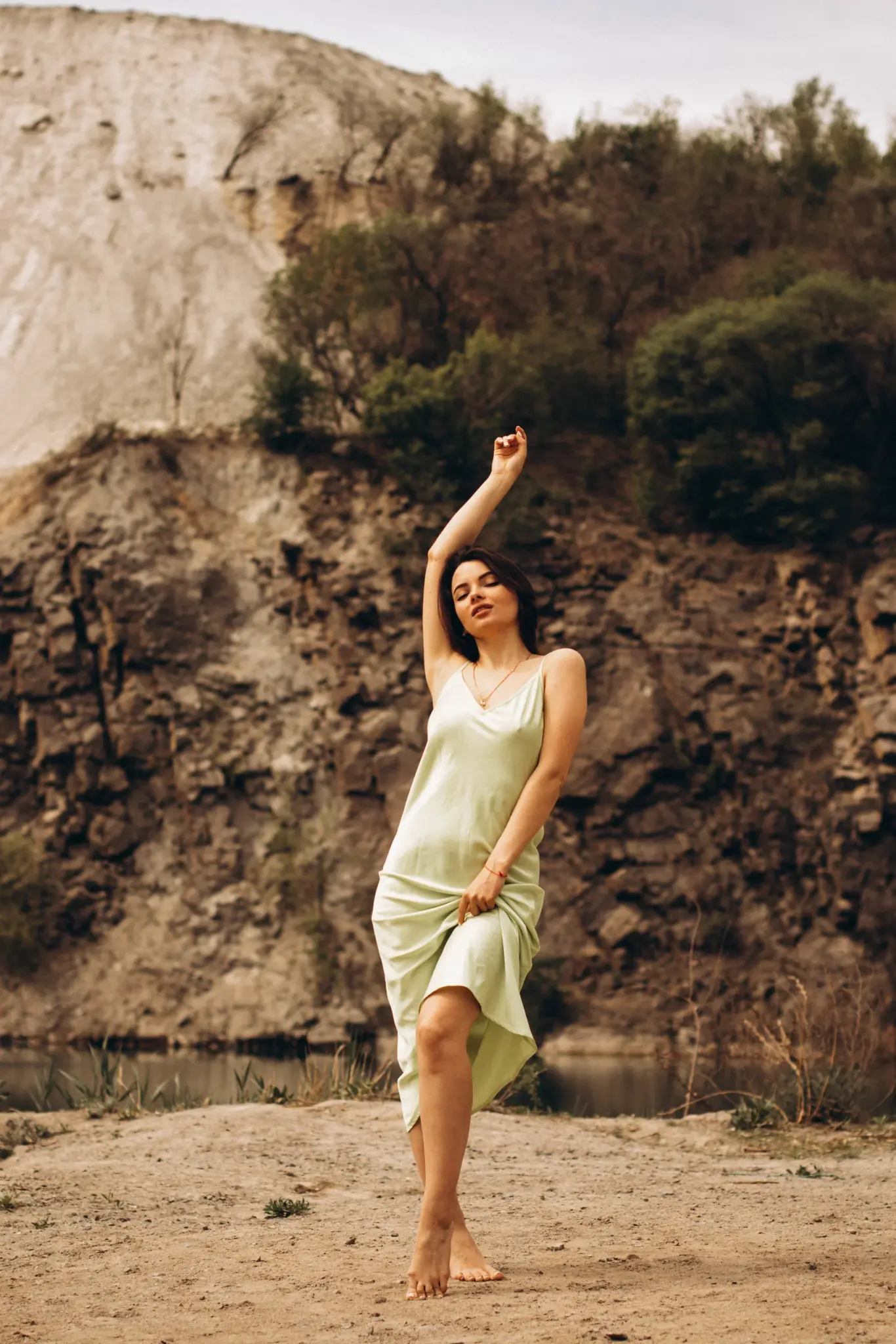 Christina dancing on a rock in a green silk dress