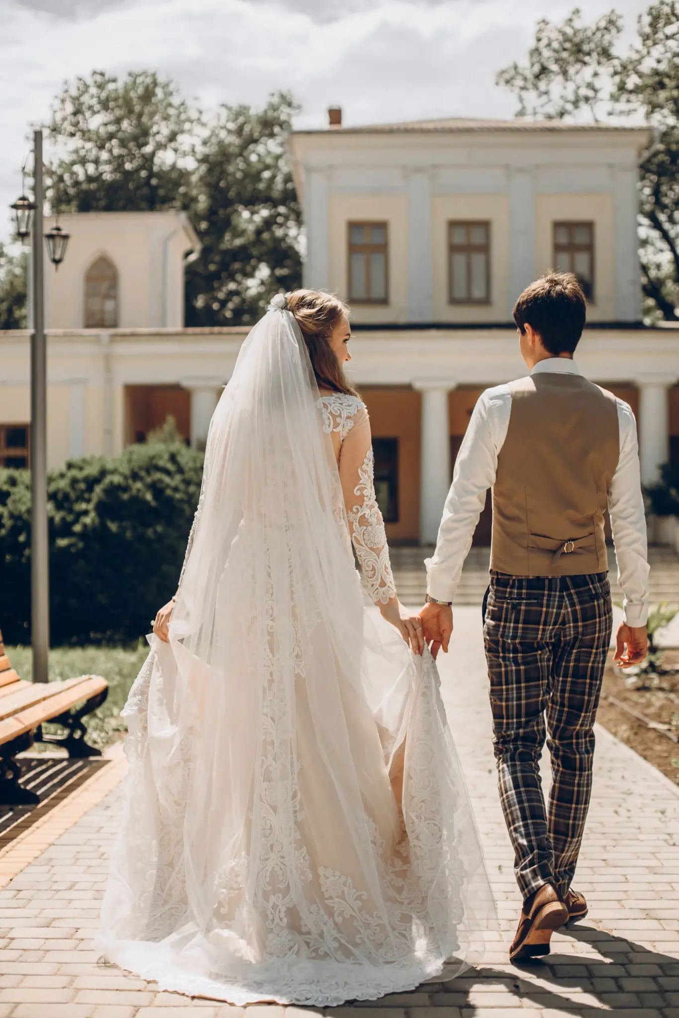 Bride and groom walking toward a white villa