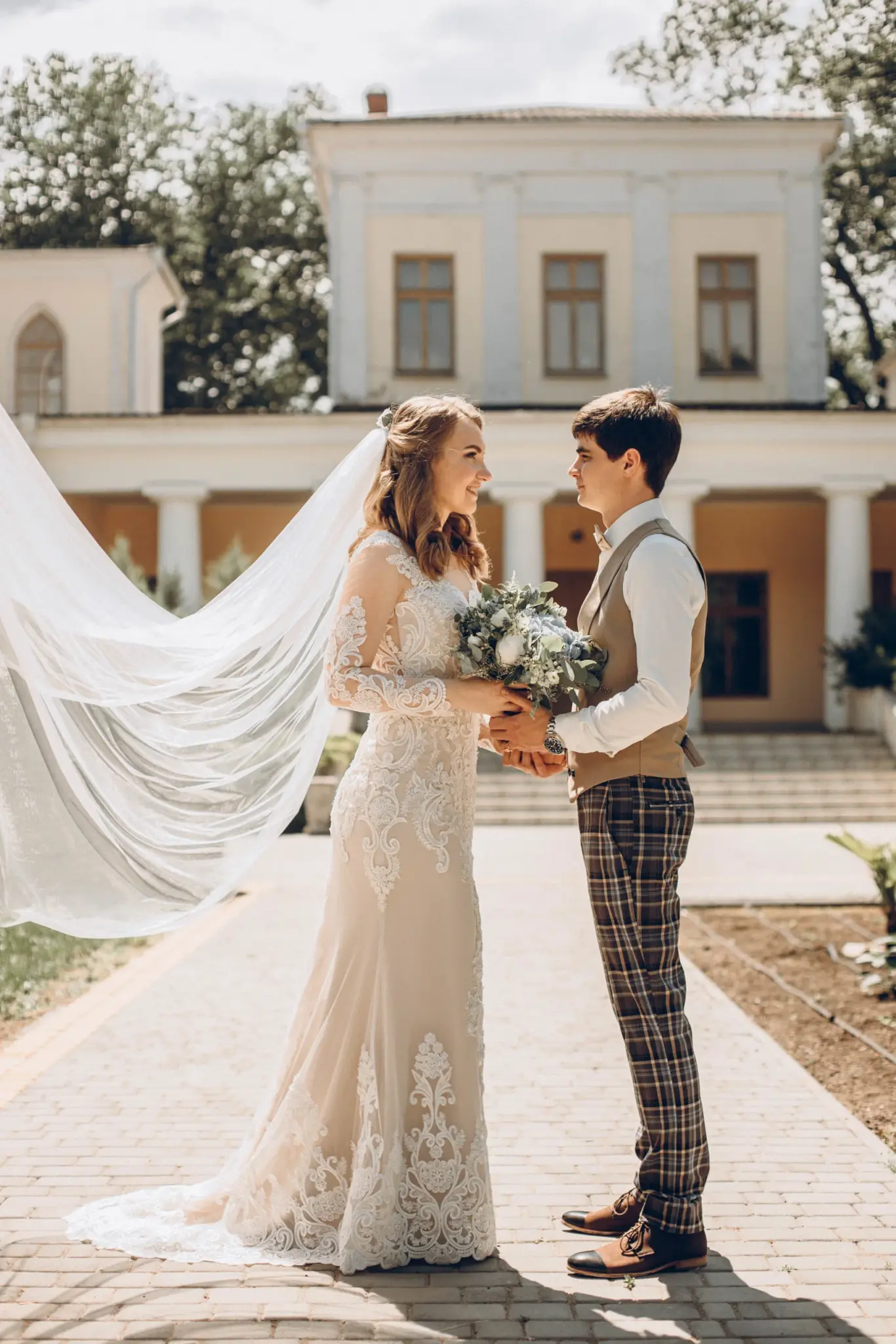 Bride and groom face to face in front of the villa