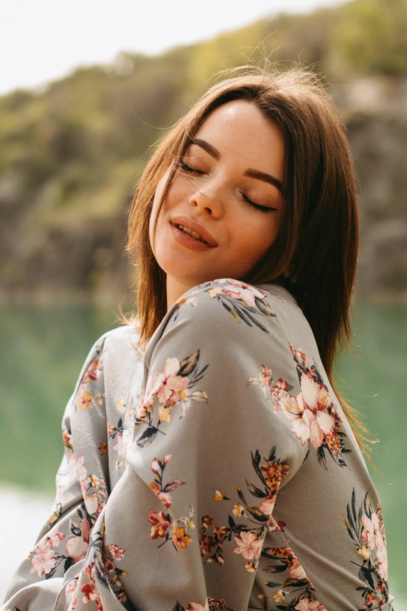 Close portrait of Christina in a floral dress smiling over her shoulder