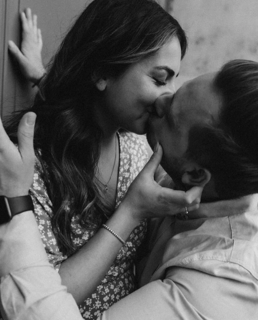 Parents-to-be sharing a kiss at a black and white maternity photoshoot in Paris