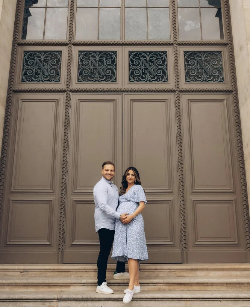 Expecting couple at a maternity photoshoot in Paris by grand ornate doors on