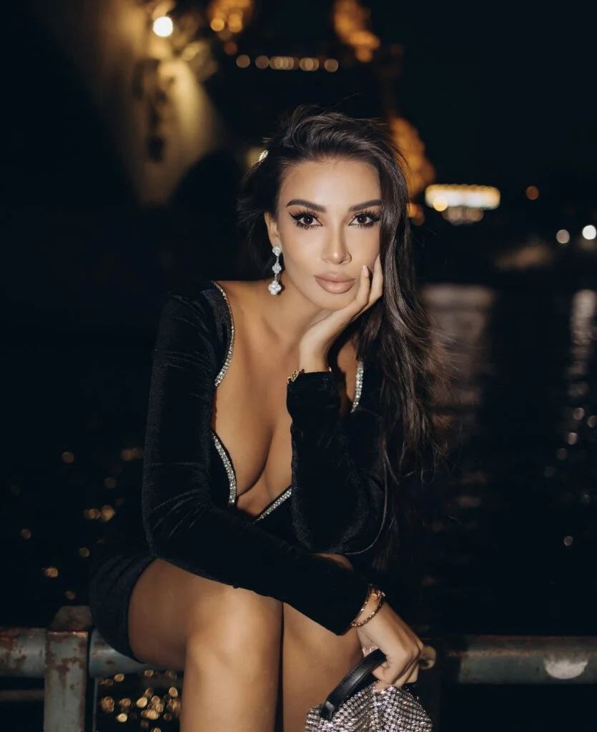Elegant close-up night portrait photography in Paris, a woman in a black velvet dress against warm city bokeh