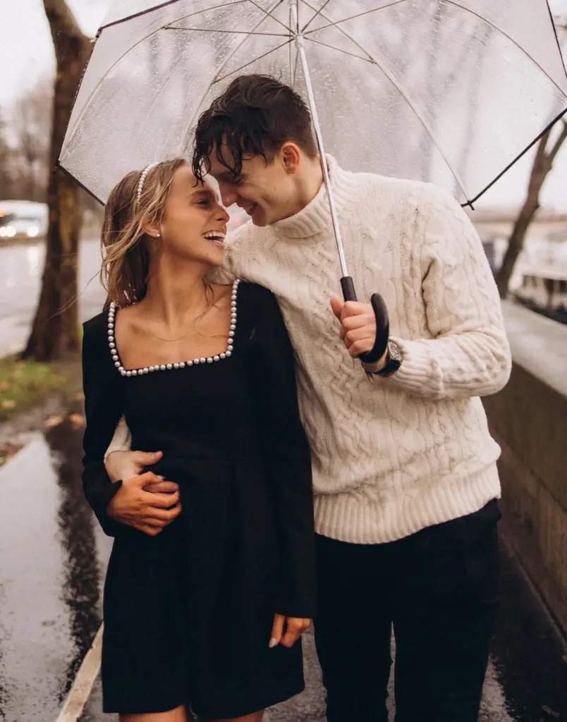 Couple laughing under a clear umbrella in the rain, photographed by couples photographer Julia Litvin in Paris