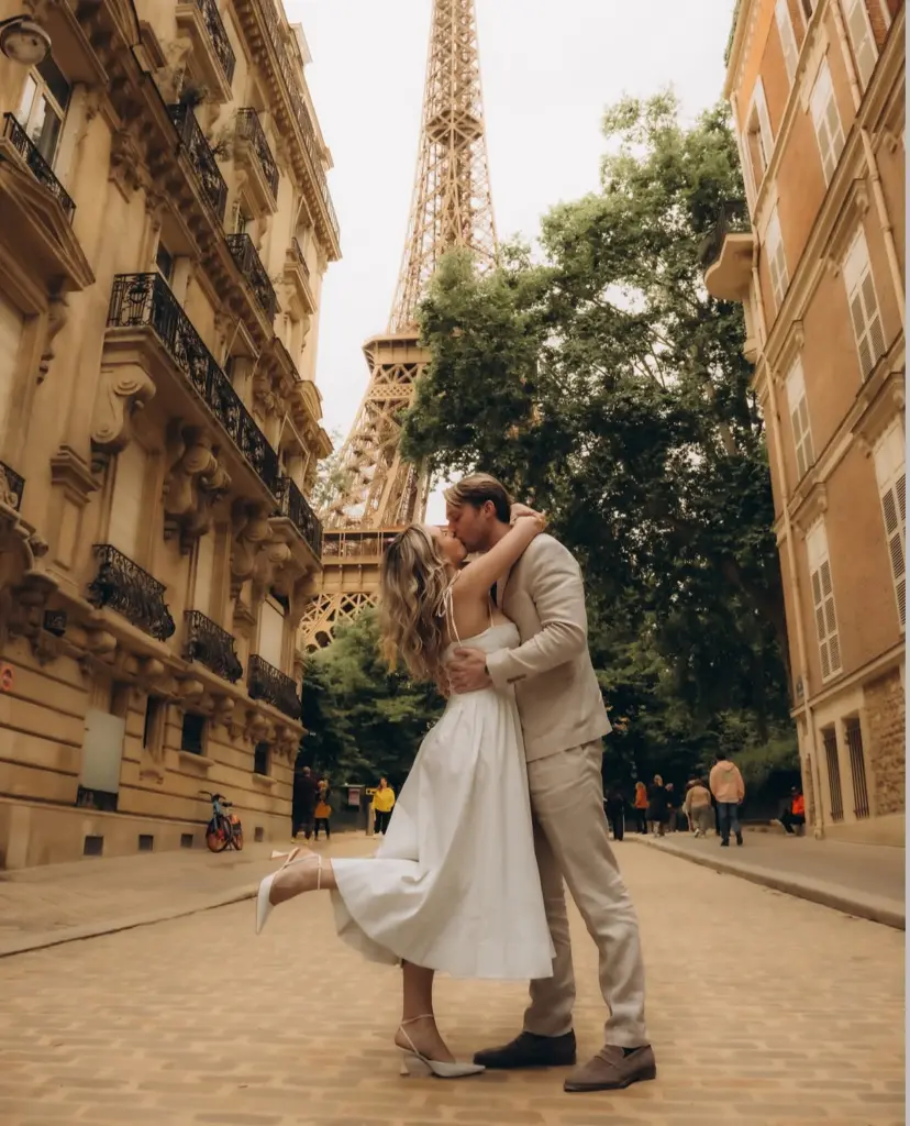 Couple kissing near Rue de l'Université - Couple kissing on a cobbled Paris street between Haussmann balconies, photographed by couples photographer Julia Litvin