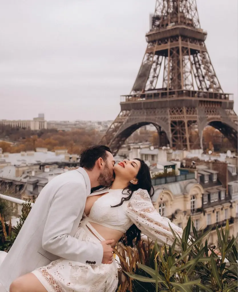 Romantic photoshoot for couples on a Paris rooftop terrace in autumn, a couple in white above the Haussmann roofs, by Julia Litvin