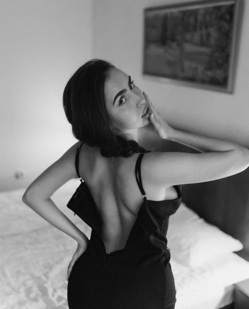 An elegant boudoir photo session by Julia Litvin, boudoir photographer in Paris. Turning gracefully over the shoulder in a refined black slip dress, this black and white portrait captures the poise, elegance, and quiet confidence I bring to every session. See more at