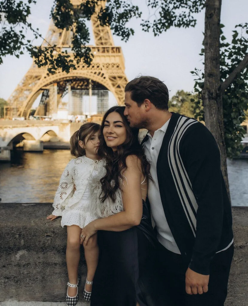 Paris family photographer capturing parents with their little daughter on the riverside at sunset