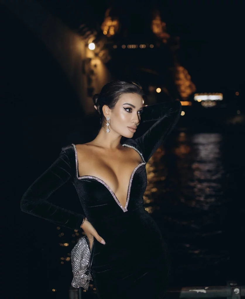 Chic evening fashion portrait photography in Paris, a woman in a black velvet gown by the river at night