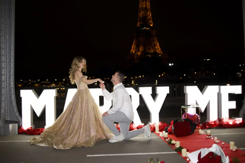 Paris proposal photographer captures a man kneeling before giant lit Marry Me letters at night