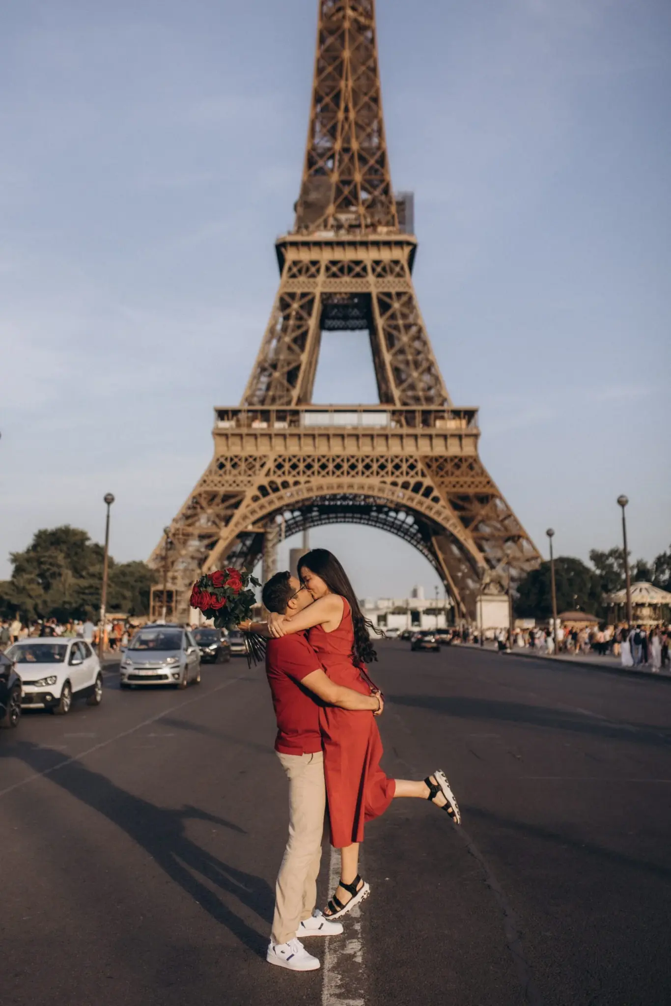 Couple embracing in the middle of the street with the Eiffel Tower behind them