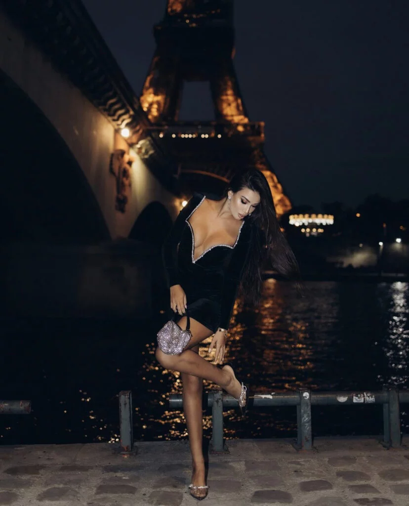 Glamorous night portrait photography in Paris, a woman in a black velvet dress by the Seine with the Eiffel Tower behind