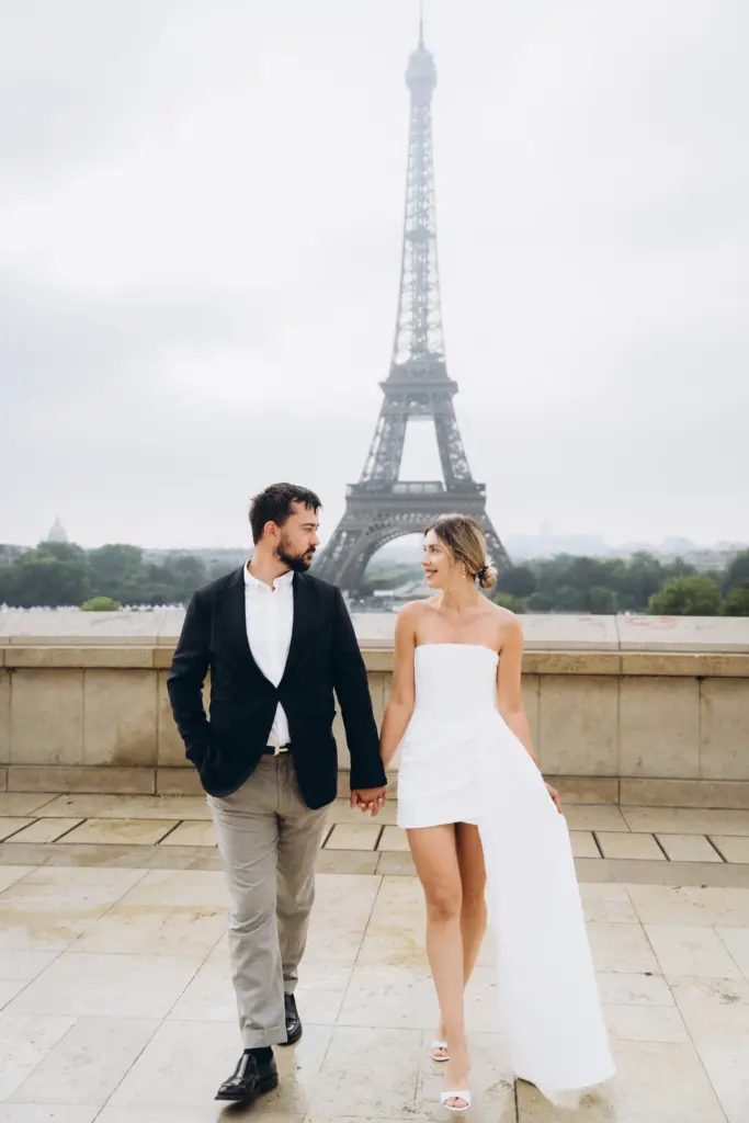 Anatolii and Julia, Paris photographers, walking at the Trocadéro with the Eiffel Tower behind them