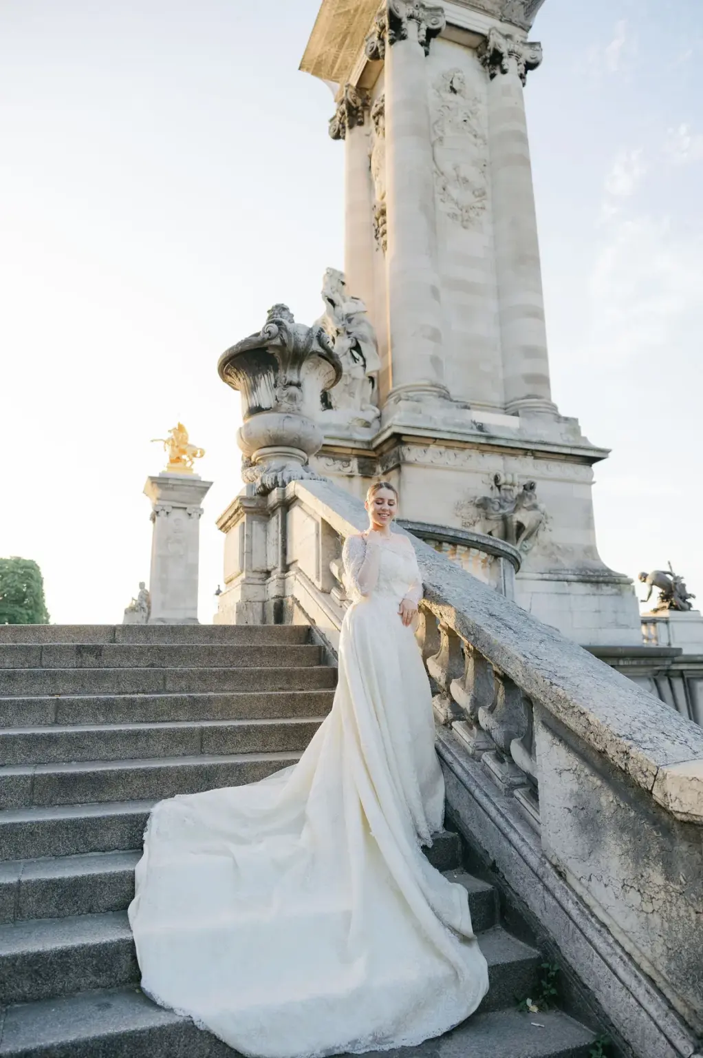 Elegant solo bridal portrait in Paris on the steps of Pont Alexandre III at sunrise