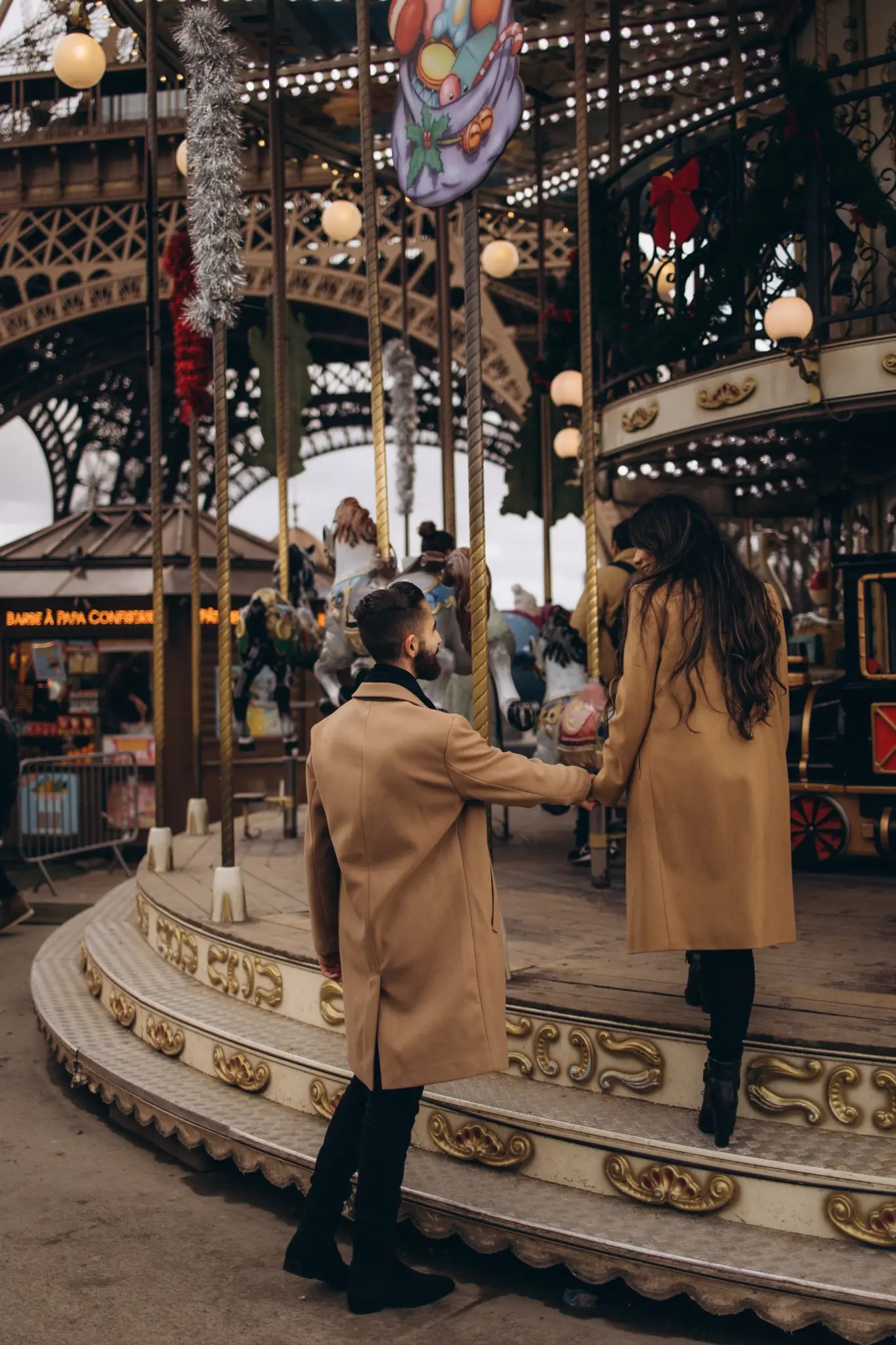 Couple kissing by the carousel at the foot of the Eiffel Tower