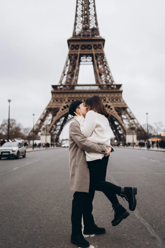 Man lifting his partner in the middle of the road under the Eiffel Tower
