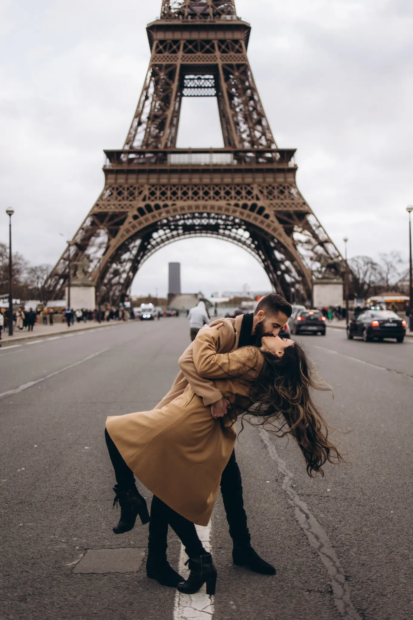 Man dipping his partner for a kiss under the Eiffel Tower at Pont d’Iéna