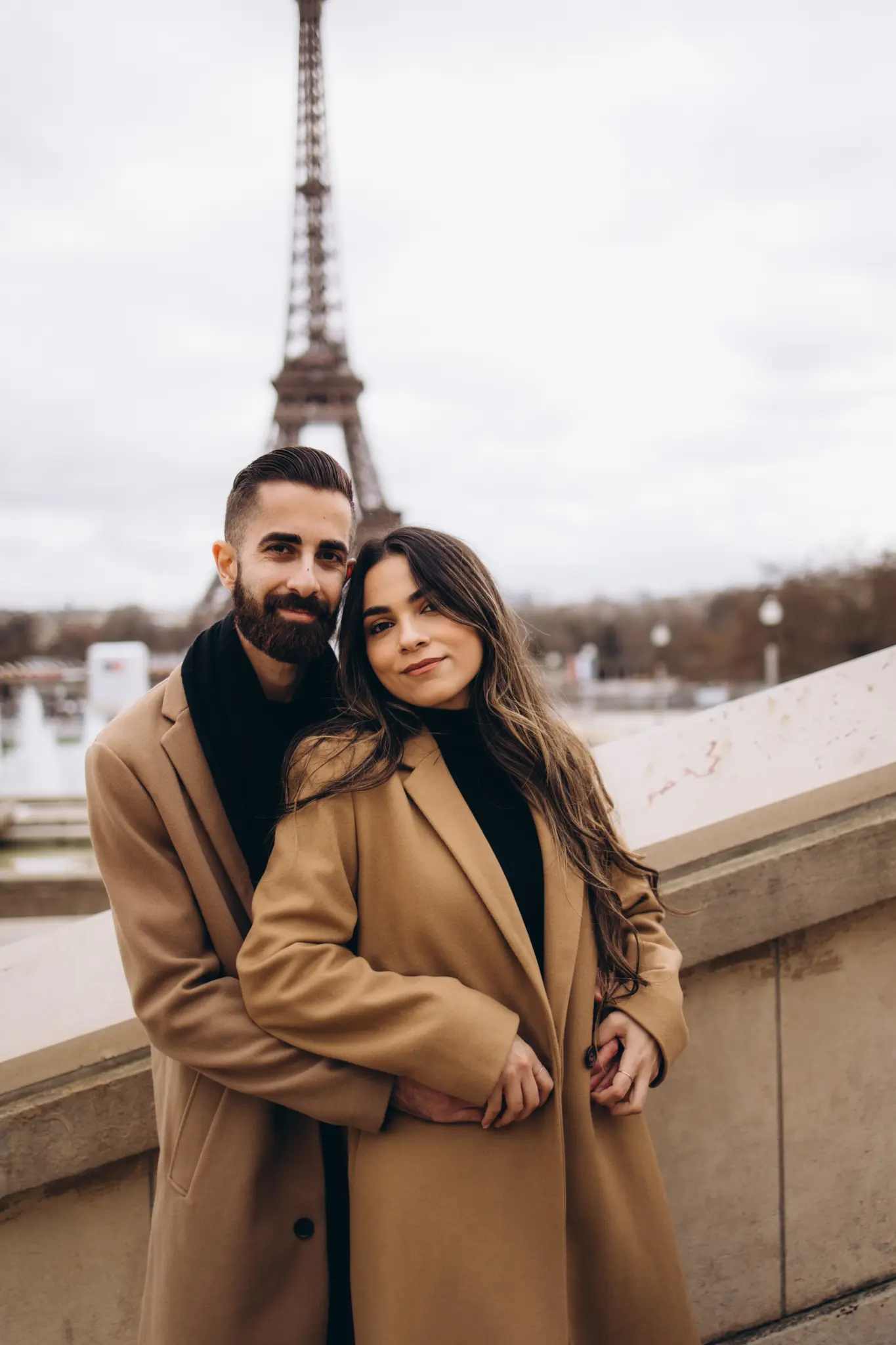 Couple on the stone stairs below Avenue de Camoëns with the Eiffel Tower above