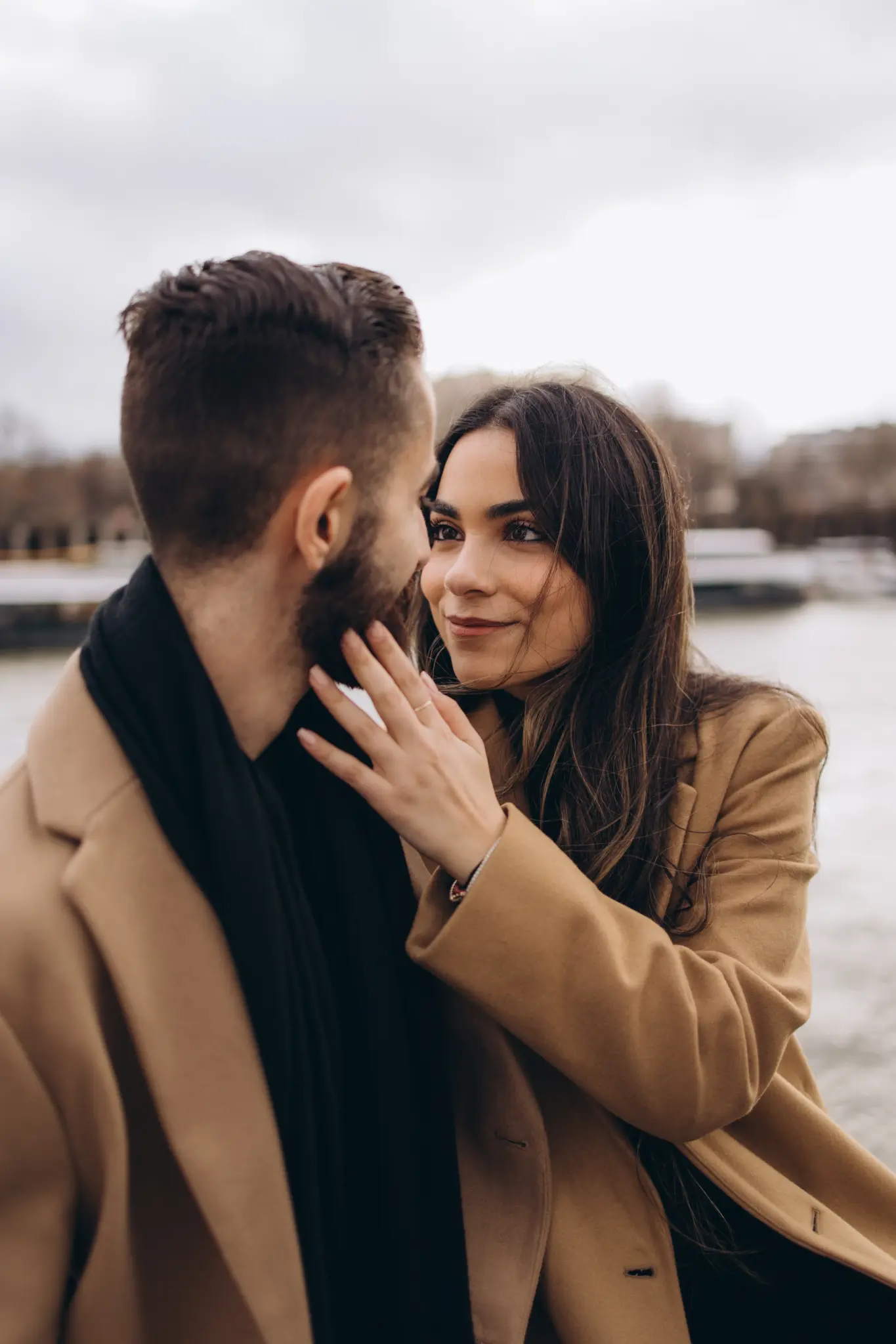 Couple embracing at the Trocadéro gardens with the Eiffel Tower behind