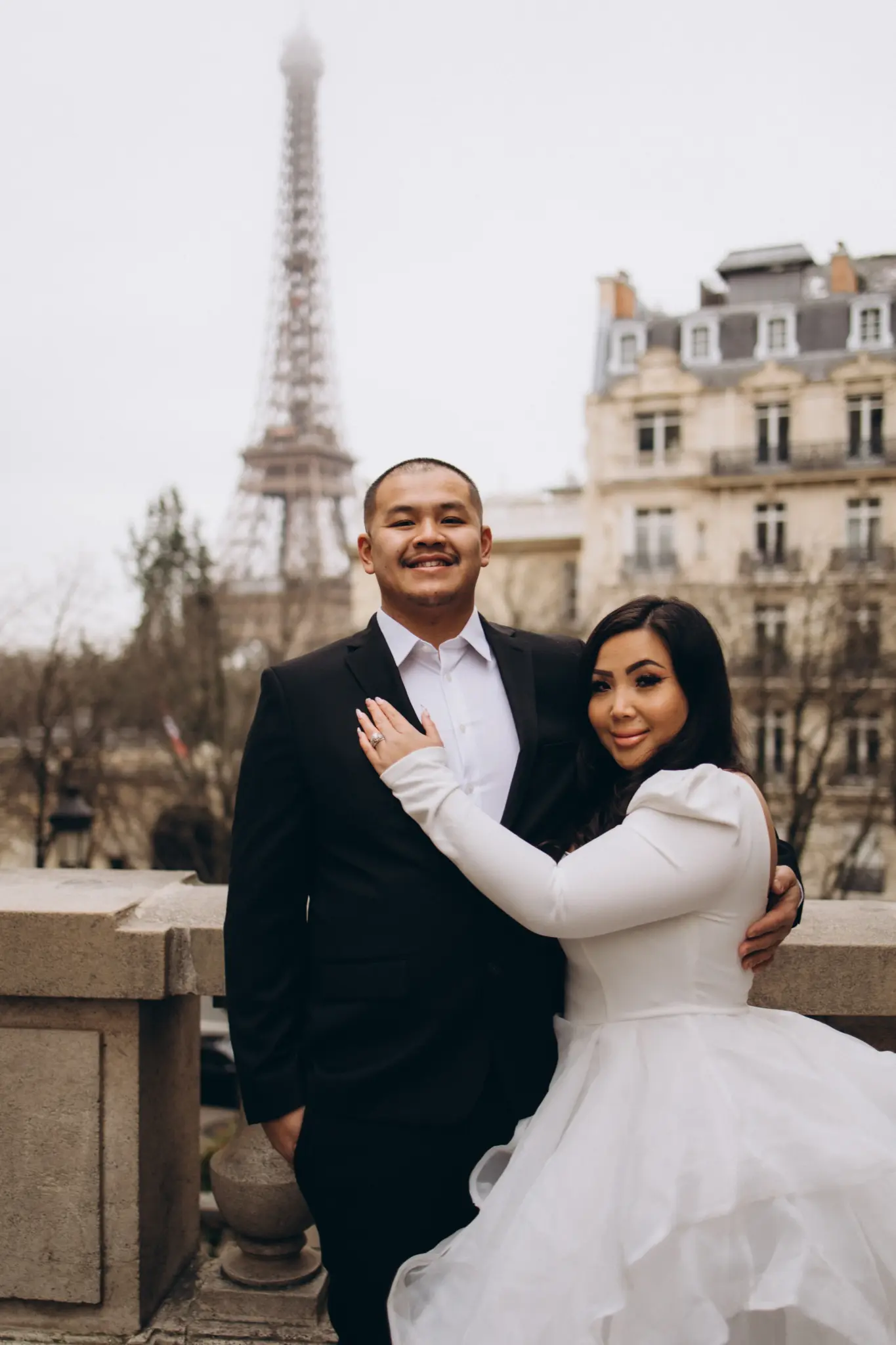 Bride holding the groom at Avenue de Camoëns with the Eiffel Tower behind