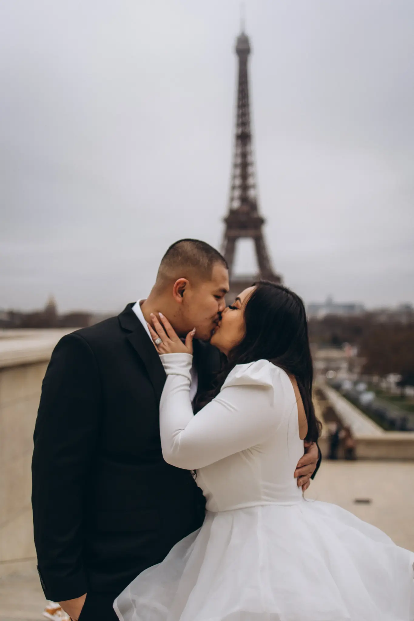 Bride and groom kissing at Trocadéro with the Eiffel Tower in the distance