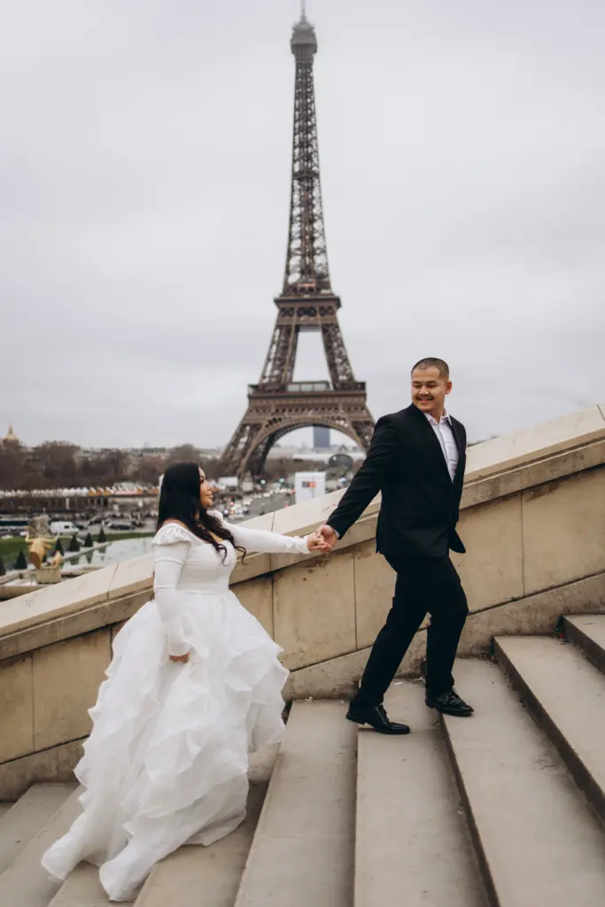Bride and groom on the Trocadéro stairs facing the Eiffel Tower