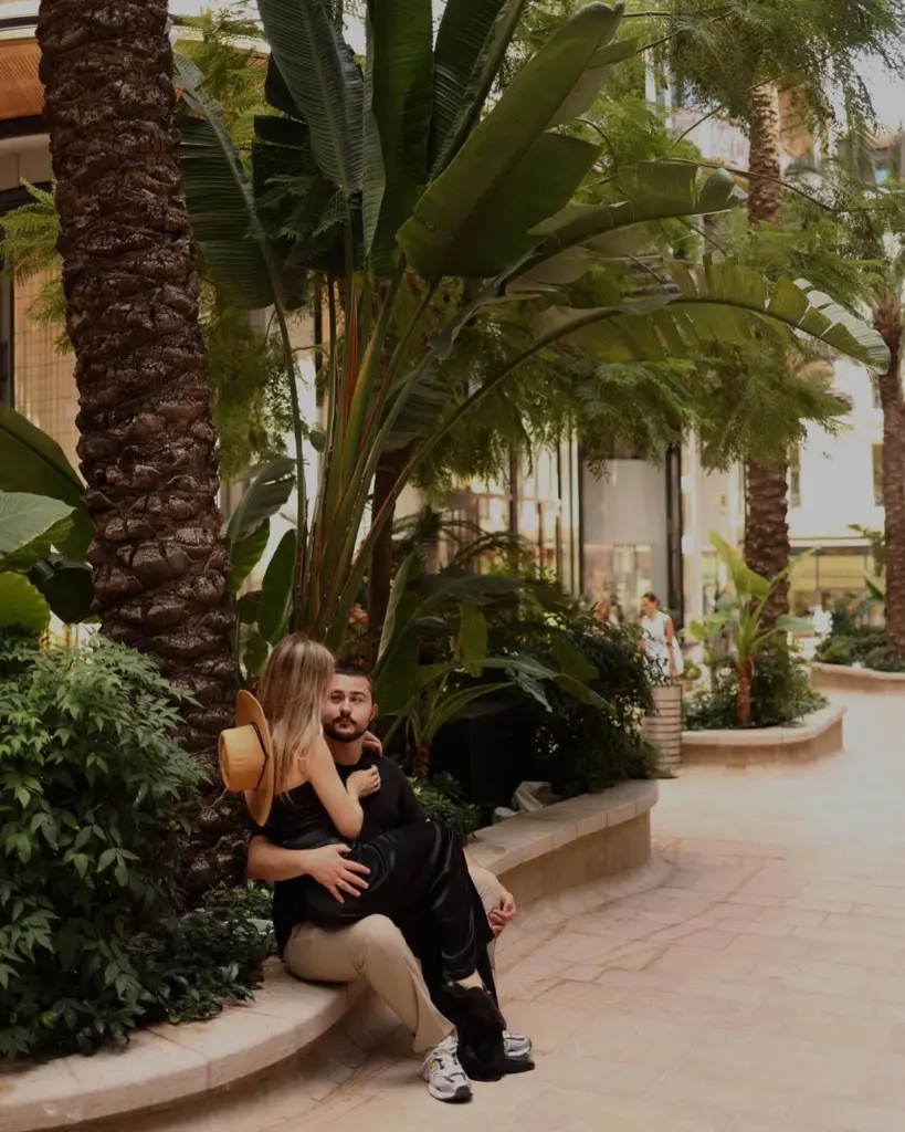 Couple sitting together among the palms of a Monte-Carlo garden, photographer in Monaco