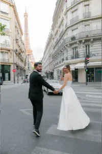 He led her across the empty crossing by the hand, she turned back over her shoulder to look at me, and the whole street seemed to hold still for a second. Golden light on pale stone, a quiet morning in the 7th, and two people who had already forgotten I was there. This is what I photograph couples in Paris for.