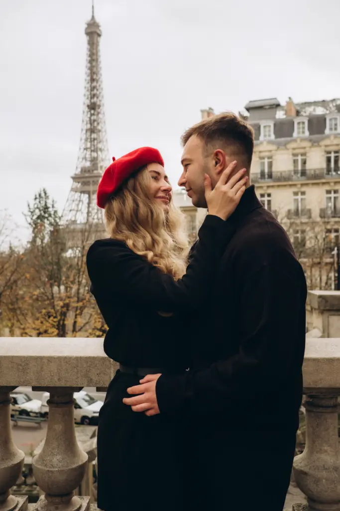 Couple embracing on a Haussmann street, the woman in a red beret, Eiffel Tower in the distance