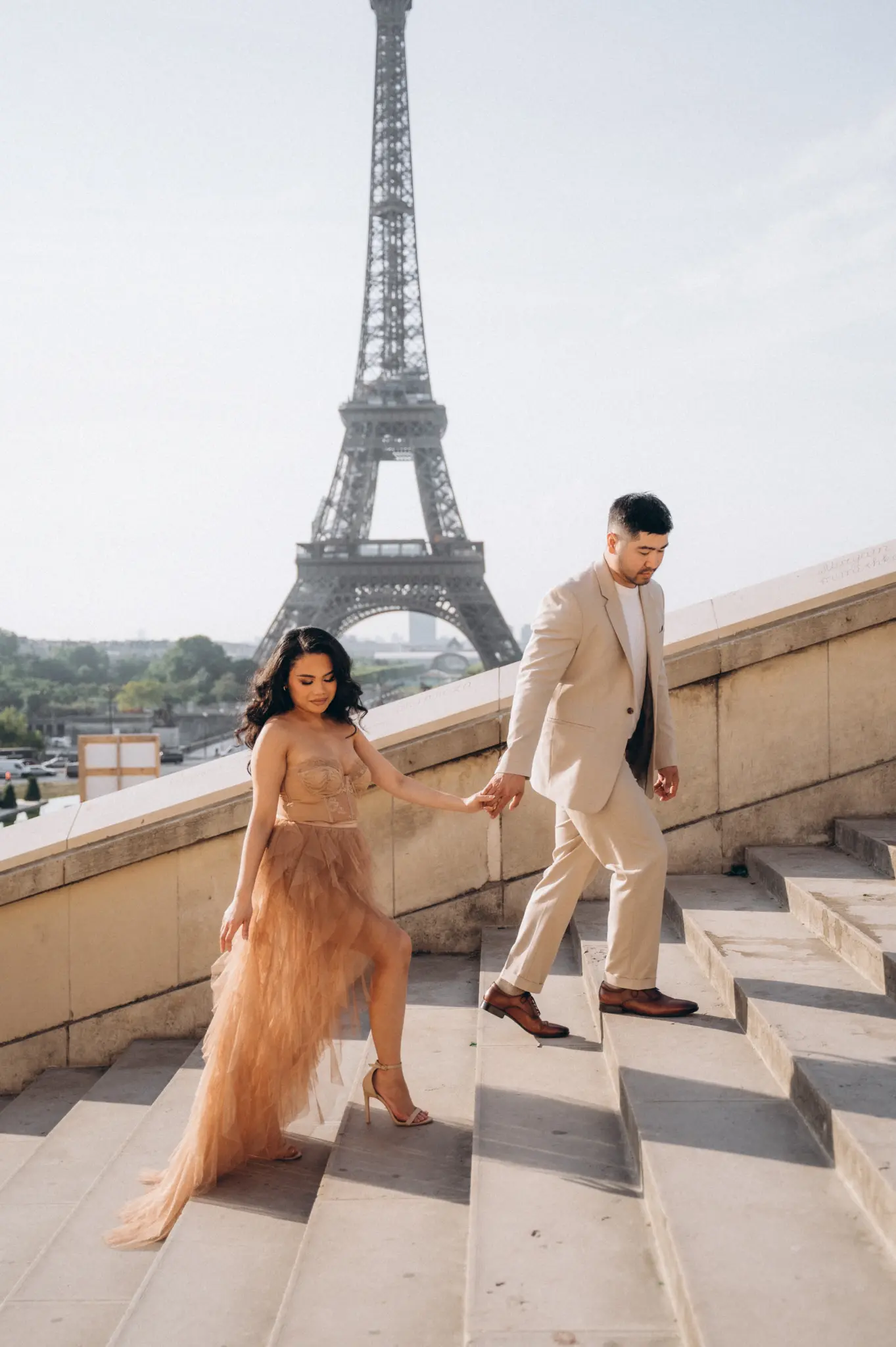Couple in champagne tones on the Trocadéro steps with the Eiffel Tower behind