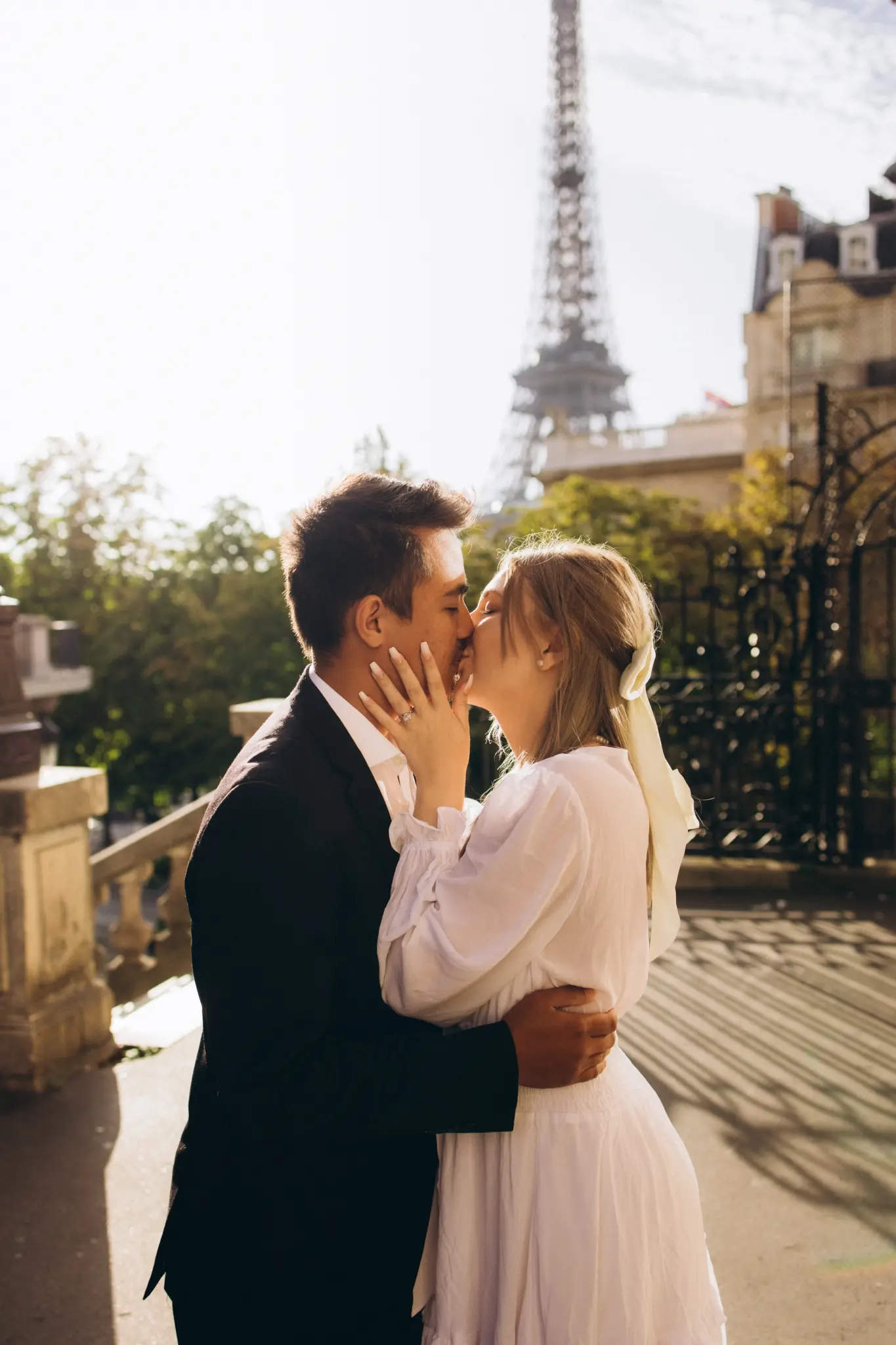 Engaged couple kissing at Avenue de Camoëns with the Eiffel Tower