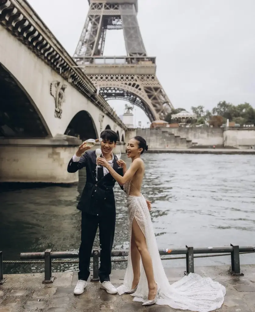 Couple by the arches of Pont d’Iéna on the Seine, Eiffel Tower behind