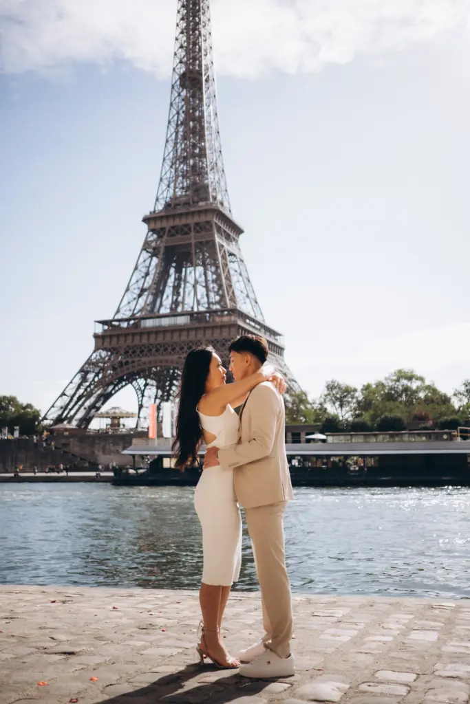 Engaged couple by the Seine with the Eiffel Tower