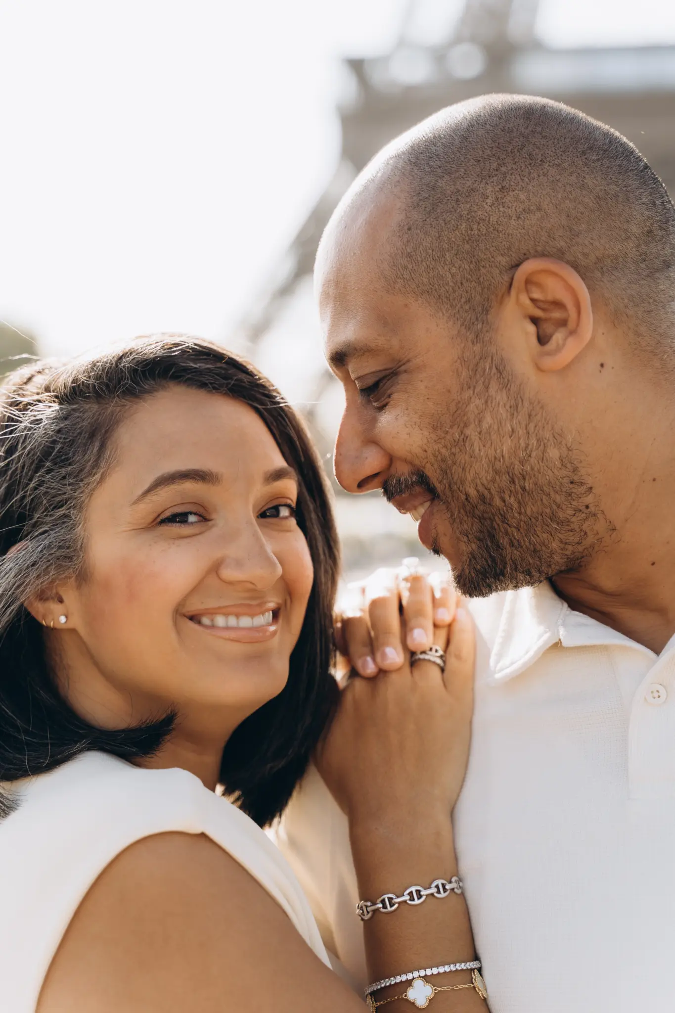 Close portrait of a mother smiling with her husband, Eiffel Tower soft in the background