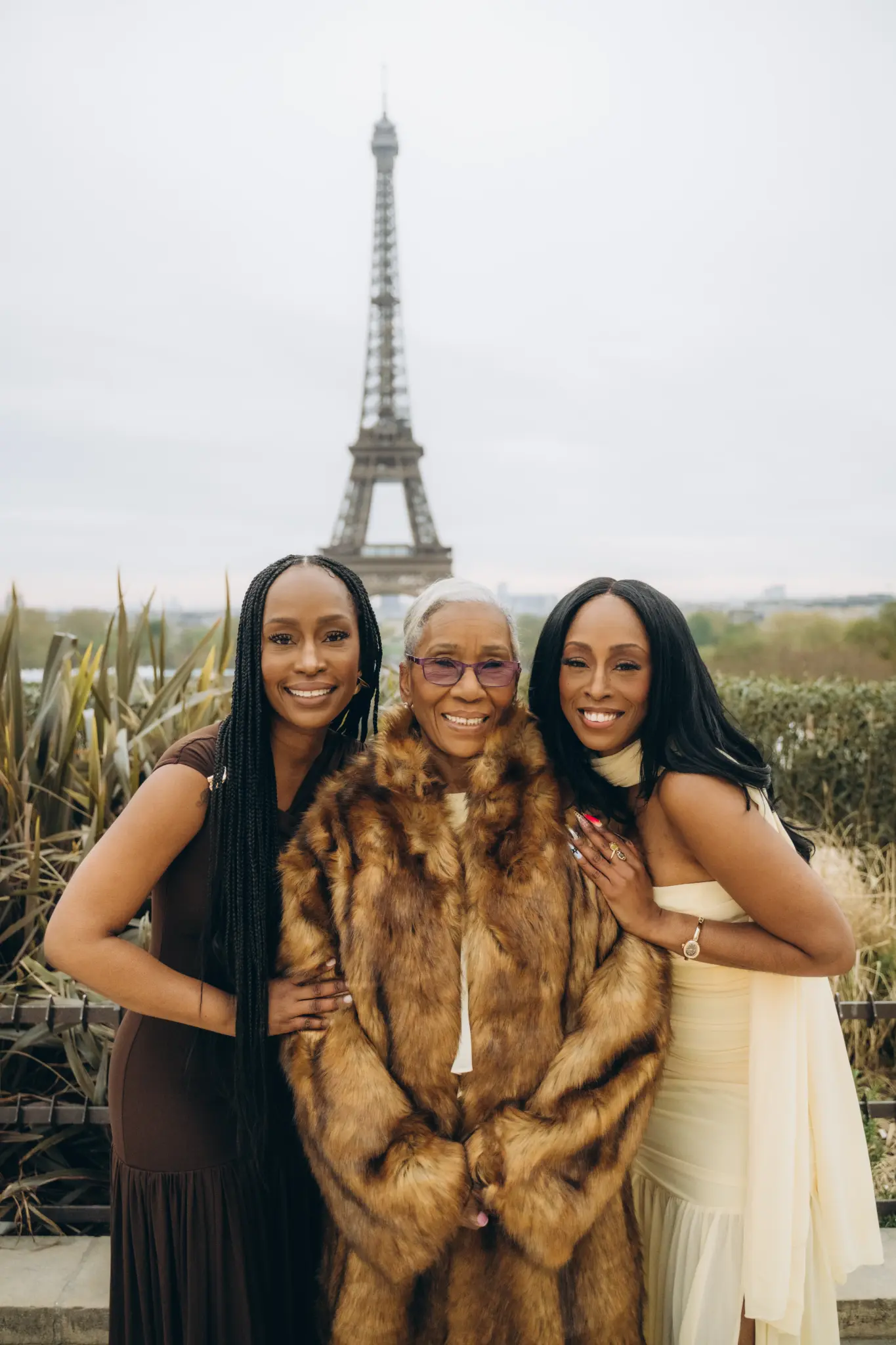 Three generations of women with the grandmother in a fur coat at Trocadéro, Eiffel Tower behind