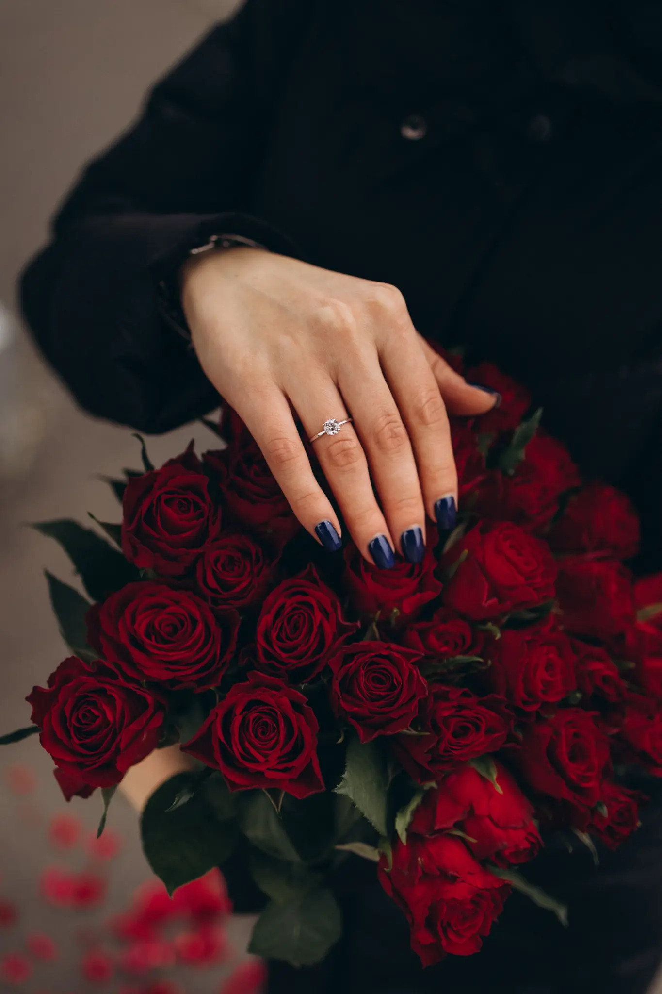 Engagement ring over a bouquet of red roses in Paris