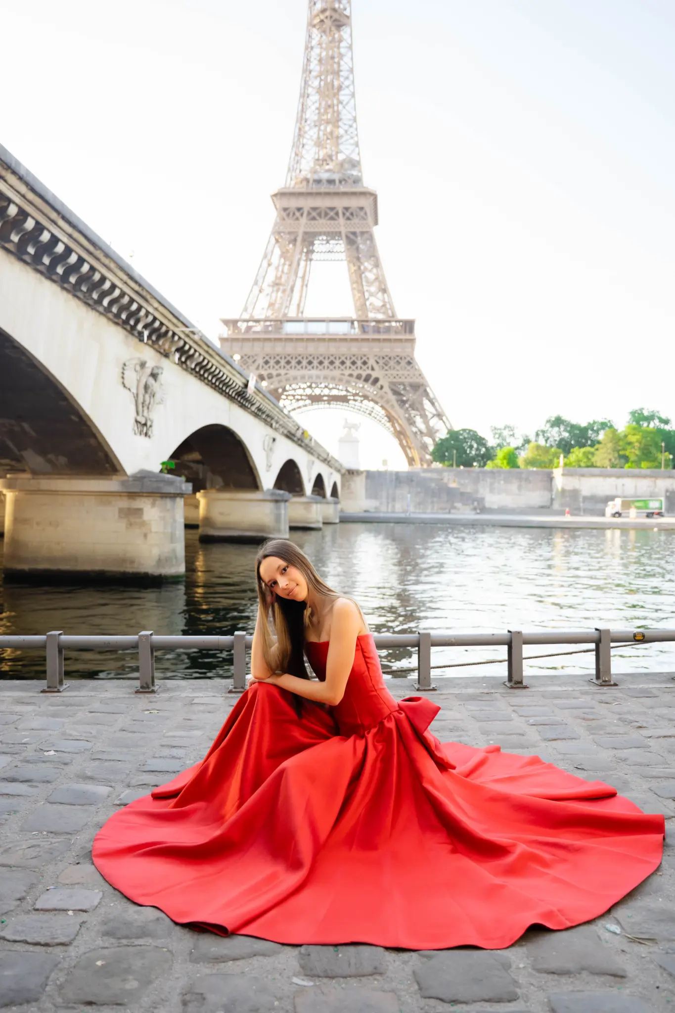 Quinceañera in a red gown on the Seine quay below Pont d’Iéna and the Eiffel Tower