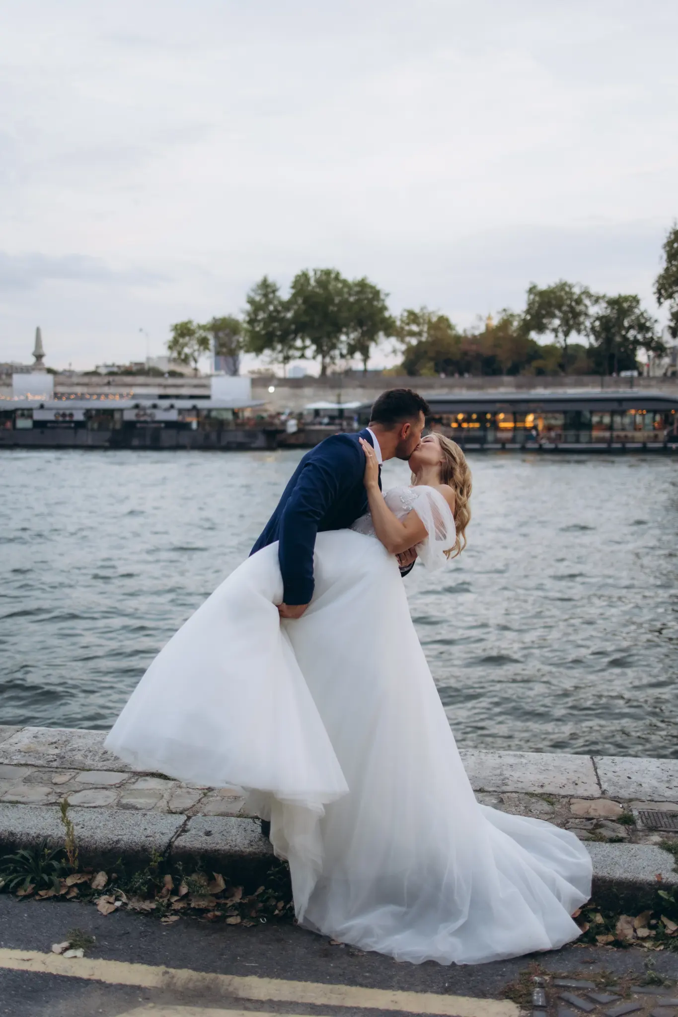 Groom dipping the bride for a kiss on the quay of the Seine